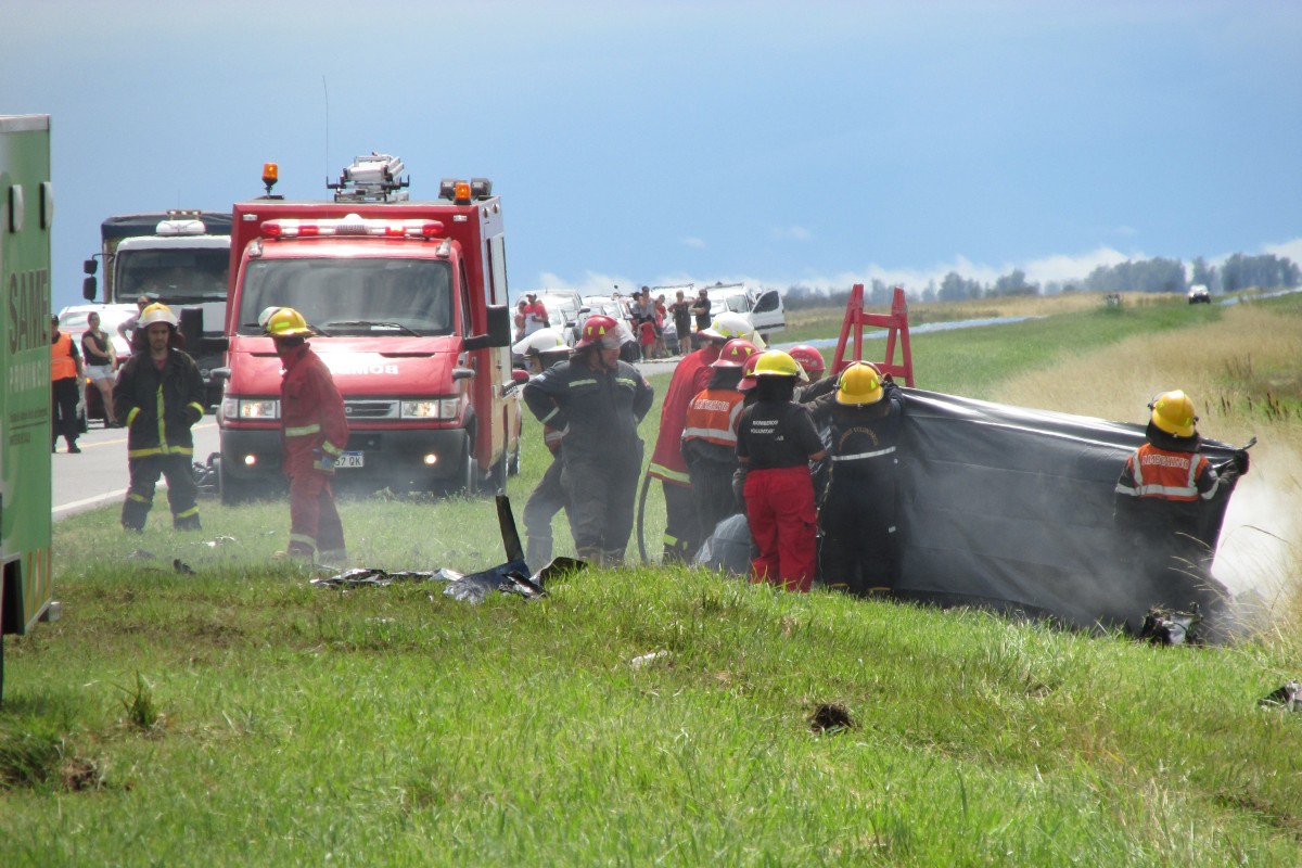 Los bomberos trabajan sobre el auto incendiado (Foto: gentileza Diario Actualidad)
