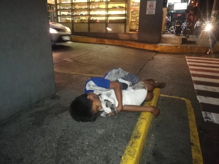 La foto que conmueve e indigna: un chico de la calle duerme abrazado a su perro en Filipinas