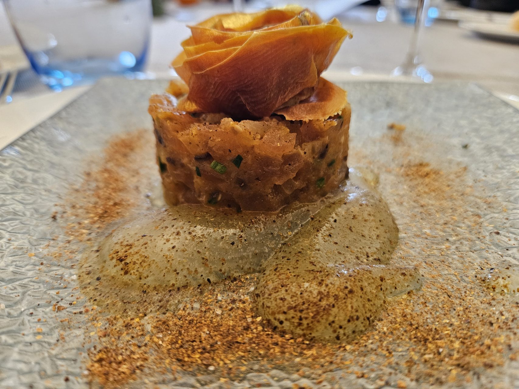 Tartar de tomate coronado con una rosa de piel del fruto