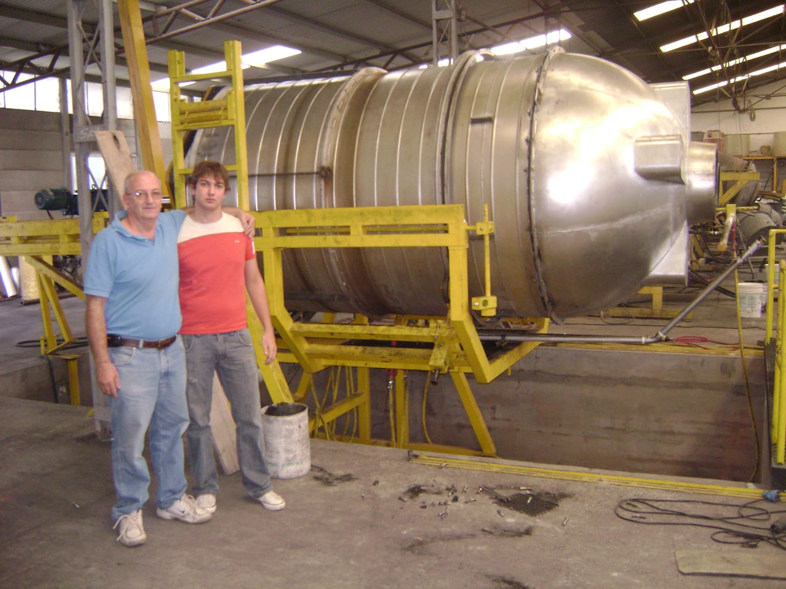 Sergio y Matías Paesani frente a una imponente estructura de acero inoxidable. La firma pampeana se destaca por diseñar y fabricar maquinarias complejas a medida para diversas industrias.